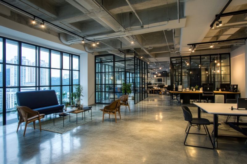 Modern open plan office space with glass partitions, polished concrete floors, and city views
